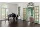 Elegant living room with hardwood floors, piano, and view into bonus room with green accents at 401 Peachtree Battle Nw Ave, Atlanta, GA 30305