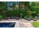 A comfortable outdoor patio area featuring a pool, lounge seating, and lush landscaping at 401 Peachtree Battle Nw Ave, Atlanta, GA 30305