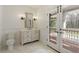 Cozy bathroom with a vanity, toilet, and french doors to a balcony and a view of the exterior at 0 Winterthur, Sandy Springs, GA 30328