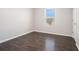 A cozy bedroom with light gray walls and dark wood-look flooring complemented by a window for natural light at 2398 Chancery Mill Ln, Buford, GA 30519