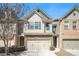 Charming townhome featuring a two-car garage and stone accents on the facade at 2398 Chancery Mill Ln, Buford, GA 30519
