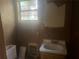 Bathroom featuring a sink, toilet, window and outdated decor needing renovation at 294 Hascall Nw Rd, Atlanta, GA 30309