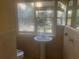 Cozy bathroom with a pedestal sink and window, showcasing a simple, functional design at 294 Hascall Nw Rd, Atlanta, GA 30309