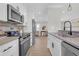 Bright kitchen with stainless steel appliances, white cabinets, and light wood-look floors at 3235 Bluebird Ln, Decatur, GA 30032