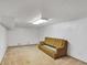 This basement features carpeting and a couch at 4676 Ridgewood Dr, Forest Park, GA 30297