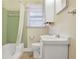 This bathroom features a bathtub, tiled walls, window, toilet and sink with a vanity mirror at 4676 Ridgewood Dr, Forest Park, GA 30297
