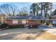 Charming one-story brick home with covered parking and a well-maintained front yard at 4676 Ridgewood Dr, Forest Park, GA 30297