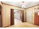 This living room has wood-paneled walls and an entrance with folding doors to another room at 4676 Ridgewood Dr, Forest Park, GA 30297