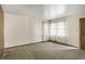 Spacious living room features carpet, natural light, and a classic paneled wall at 4676 Ridgewood Dr, Forest Park, GA 30297