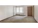Bright living room features a large window with sheer curtains and a neutral carpet at 4676 Ridgewood Dr, Forest Park, GA 30297