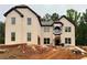 An unfinished two-story home with a brick facade and dark trim, set on a lot with trees in the background at 206 Lotus Ln, Covington, GA 30016