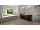 Bathroom with granite counters, double sinks, tub, and walk-in shower with glass door at 206 Lotus Ln, Covington, GA 30016
