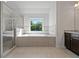 Bright bathroom with walk-in shower, soaking tub under window, and granite topped vanity at 206 Lotus Ln, Covington, GA 30016
