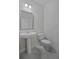 Modern powder room featuring a pedestal sink, toilet, and updated light fixture at 206 Lotus Ln, Covington, GA 30016