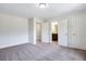 A clean bedroom with multiple doorways, neutral color palette, and lush carpet adds to the natural tones of the home at 218 Lotus Ln, Covington, GA 30016