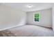 Bright, carpeted bedroom with a large window allowing natural light at 218 Lotus Ln, Covington, GA 30016