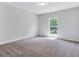 Bedroom featuring neutral carpet, gray walls, white trim, and a view of the outdoors at 218 Lotus Ln, Covington, GA 30016