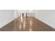 Long hallway with hardwood floors leading to rooms with neutral walls at 227 Wild Ginger Bnd, Woodstock, GA 30188