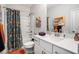 Bright bathroom with floral shower curtain, white vanity, and decorative artwork at 233 Retreat Ln, Canton, GA 30114