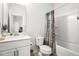 Clean bathroom features a shower-tub combo with a decorative shower curtain, vanity, and toilet at 233 Retreat Ln, Canton, GA 30114