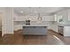 Modern kitchen features white cabinets, a gray island, stainless steel appliances, and hardwood flooring at 255 Lotus Ln, Covington, GA 30016