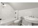 Well-lit bathroom featuring white fixtures, marble tile, and a shower-tub combo at 270 Piedmont Ne Rd, Marietta, GA 30066