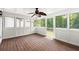 Bright sunroom featuring hardwood floors, white wainscoting, and multiple large windows with views of the outdoor greenery at 270 Piedmont Ne Rd, Marietta, GA 30066