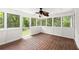Bright sunroom featuring hardwood floors, white wainscoting, and multiple large windows with views of the outdoor greenery at 270 Piedmont Ne Rd, Marietta, GA 30066