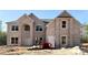 New two-story brick home with large windows and an arched entryway awaits your personal touches at 221 Lotus Ln, Covington, GA 30016