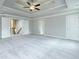 Spacious main bedroom boasts a tray ceiling, fan, and access to hallway and ensuite at 221 Lotus Ln, Covington, GA 30016