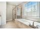 Bright bathroom featuring a glass shower and separate tub with tile surround and neutral color palette at 2402 Palladian Manor Se Way # 3, Atlanta, GA 30339