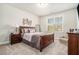 Cozy bedroom features a wooden bed frame, carpet, and a large window for natural light at 2402 Palladian Manor Se Way # 3, Atlanta, GA 30339