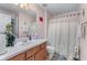 Bathroom featuring a large mirror, white shower curtain, and wooden vanity at 3920 Vine Gate Dr, Lithonia, GA 30038