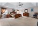 Large bedroom with tray ceilings featuring neutral walls, ceiling fan, and lots of natural light at 3920 Vine Gate Dr, Lithonia, GA 30038