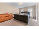 Carpeted bedroom featuring large bed, dresser and two windows at 3920 Vine Gate Dr, Lithonia, GA 30038