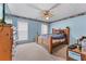 Comfortable bedroom featuring a ceiling fan, carpet floors, and blue walls with decorative border at 3920 Vine Gate Dr, Lithonia, GA 30038