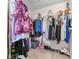 Organized walk-in closet with shelving and hanging storage, featuring various garments and accessories at 3920 Vine Gate Dr, Lithonia, GA 30038