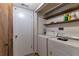 Convenient laundry area with washer, dryer, and wooden storage shelves at 922 Lakewood Ln, Jonesboro, GA 30238