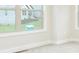 Bright bedroom features neutral walls, trim, carpet, and a view to the front yard at 211 Lotus Ln, Covington, GA 30016