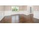 Spacious dining room with hardwood floors, wainscoting, and a large window at 211 Lotus Ln, Covington, GA 30016
