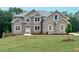 Charming two-story brick home with a well-manicured lawn and professionally landscaped yard at 211 Lotus Ln, Covington, GA 30016