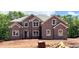New two story home shows brick facade, double windows, and neutral trim on a sunny day at 211 Lotus Ln, Covington, GA 30016