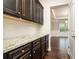 Hallway featuring dark cabinetry with granite counters and hardwood floors at 211 Lotus Ln, Covington, GA 30016