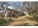 Tan house with large yard full of daffodils with mature trees surrounding property at 58 Knox Rd, Powder Springs, GA 30127