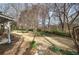 View of the backyard, with natural landscaping, newly sprouted daffodils, and a view of the side of the house at 58 Knox Rd, Powder Springs, GA 30127
