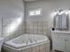 Bathroom showcasing a jacuzzi tub, vanity, and decorative window at 58 Knox Rd, Powder Springs, GA 30127
