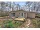 A charming tan home with a new wooden landing and a stone walkway surrounded by blooming flowers at 58 Knox Rd, Powder Springs, GA 30127