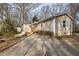 A modest home with light beige siding, accented by a gravel driveway and surrounded by early spring foliage at 58 Knox Rd, Powder Springs, GA 30127