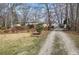 Charming single-story home with gravel driveway surrounded by trees and landscaping at 58 Knox Rd, Powder Springs, GA 30127