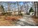 Charming single-story home with gravel driveway, storage shed, and bare-branched trees at 58 Knox Rd, Powder Springs, GA 30127